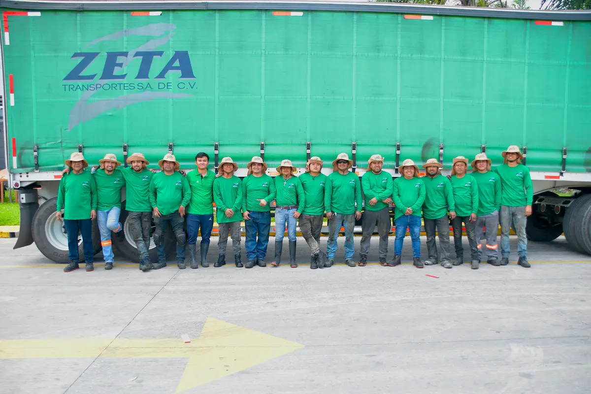 Equipo de operadores de Zeta Transportes frente a una unidad
